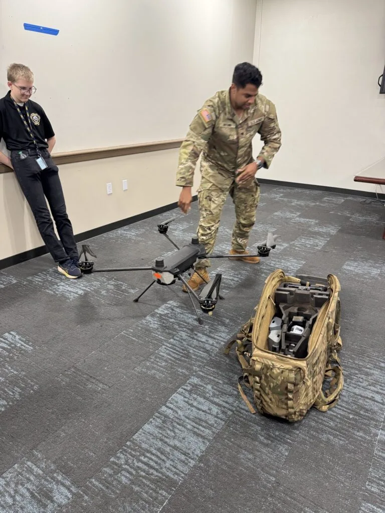A Lightning Labs soldier explaining equipment to a student