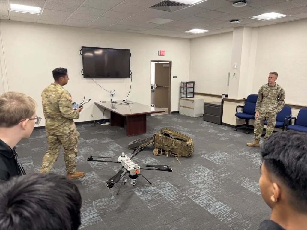 A group of students observing a UAS presentation